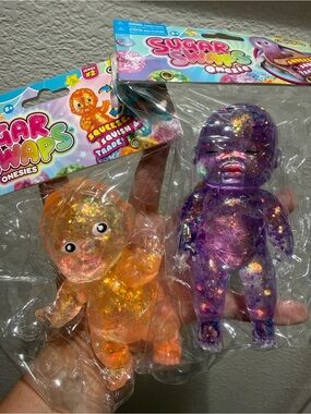 Bundle of 2 Sugar Swaps Onesie Squishy Baby. Open & Close eyes. Orange & Purple